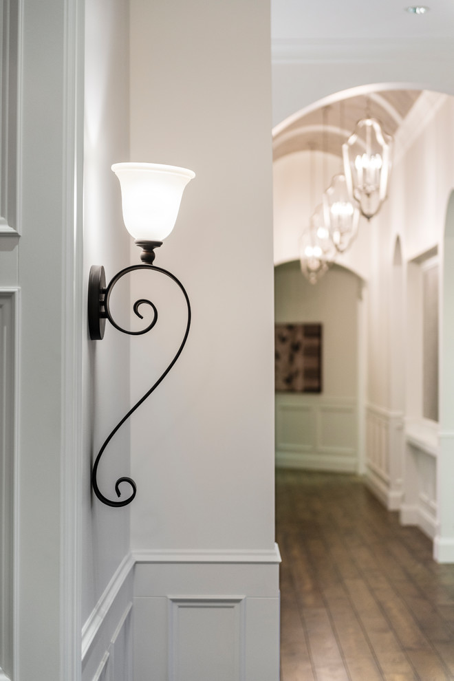 Hallway - huge rustic medium tone wood floor and brown floor hallway idea in Vancouver with white walls