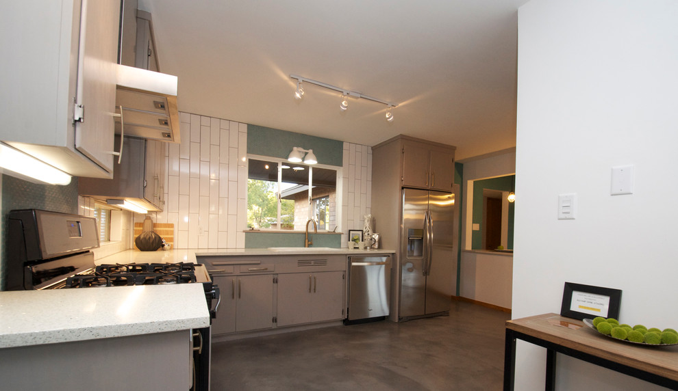 Example of a minimalist l-shaped open concept kitchen design in Phoenix with a drop-in sink, flat-panel cabinets, gray cabinets, concrete countertops, mosaic tile backsplash and stainless steel appliances