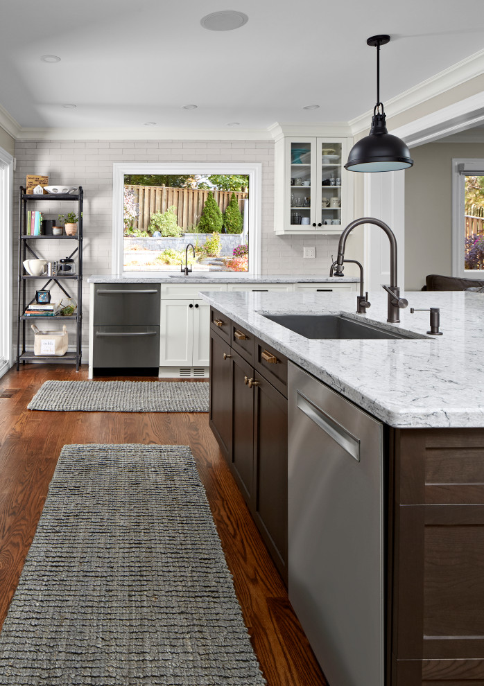 Transitional u-shaped medium tone wood floor and brown floor eat-in kitchen photo in Toronto with an undermount sink, shaker cabinets, dark wood cabinets, quartz countertops, white backsplash, subway tile backsplash, stainless steel appliances, an island and gray countertops