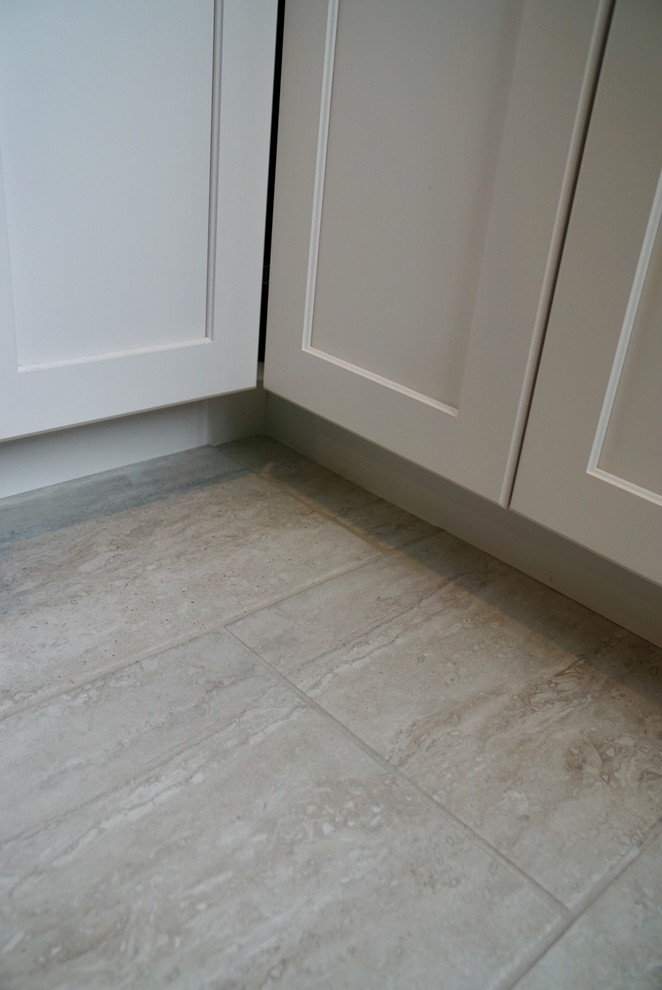 Small transitional galley porcelain tile and gray floor eat-in kitchen photo in Boston with a single-bowl sink, shaker cabinets, white cabinets, quartz countertops, gray backsplash, glass tile backsplash, stainless steel appliances and a peninsula