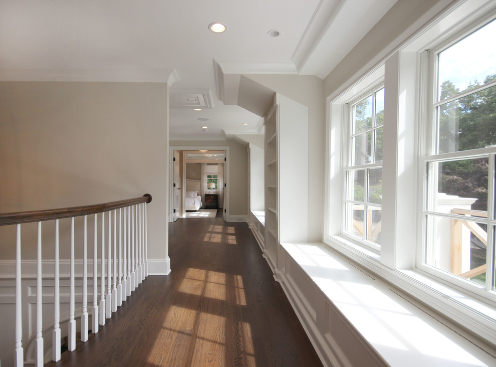 Large transitional hallway in New York with grey walls and dark hardwood floors.