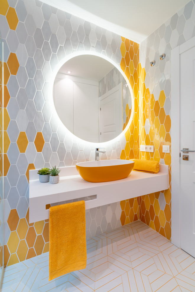 This is an example of a mid-sized contemporary 3/4 bathroom in Other with open cabinets, yellow cabinets, an open shower, a wall-mount toilet, yellow tile, ceramic tile, white walls, ceramic floors, a vessel sink, solid surface benchtops, yellow floor, an open shower, white benchtops, a single vanity and a built-in vanity.