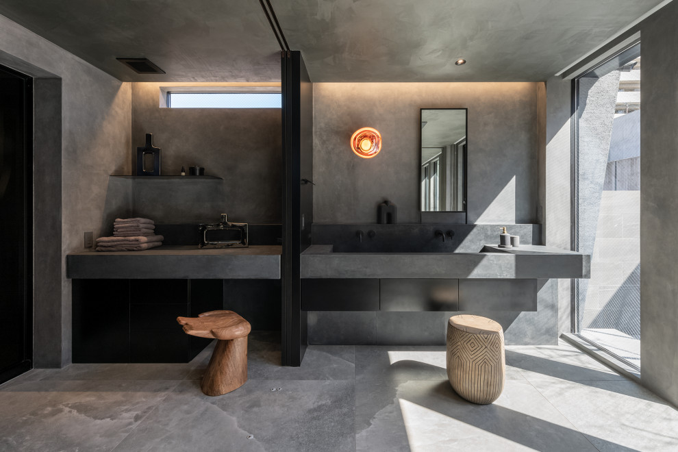 На фото: ванная комната в стиле модернизм с серыми стенами, раковиной с несколькими смесителями, серым полом, серой столешницей и тумбой под две раковины с