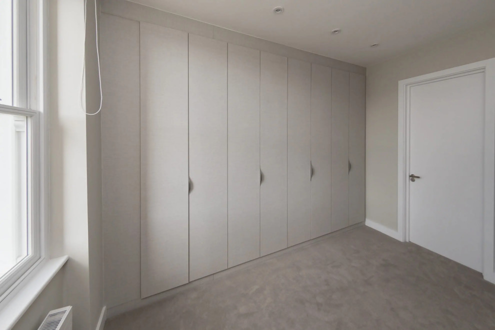 Kleines Modernes Ankleidezimmer mit Einbauschrank, flächenbündigen Schrankfronten und weißen Schränken in London