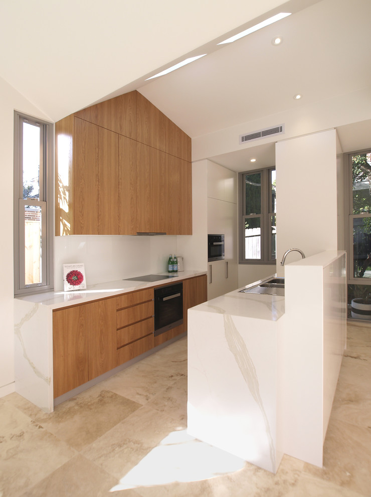 Inspiration for a mid-sized contemporary u-shaped eat-in kitchen in Sydney with a double-bowl sink, flat-panel cabinets, medium wood cabinets, quartz benchtops, white splashback, glass sheet splashback, black appliances, travertine floors and no island.