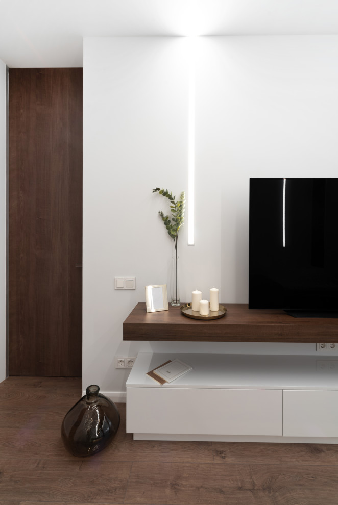 Foto di una piccola camera da letto contemporanea con pareti marroni, pavimento in laminato, pavimento marrone e TV