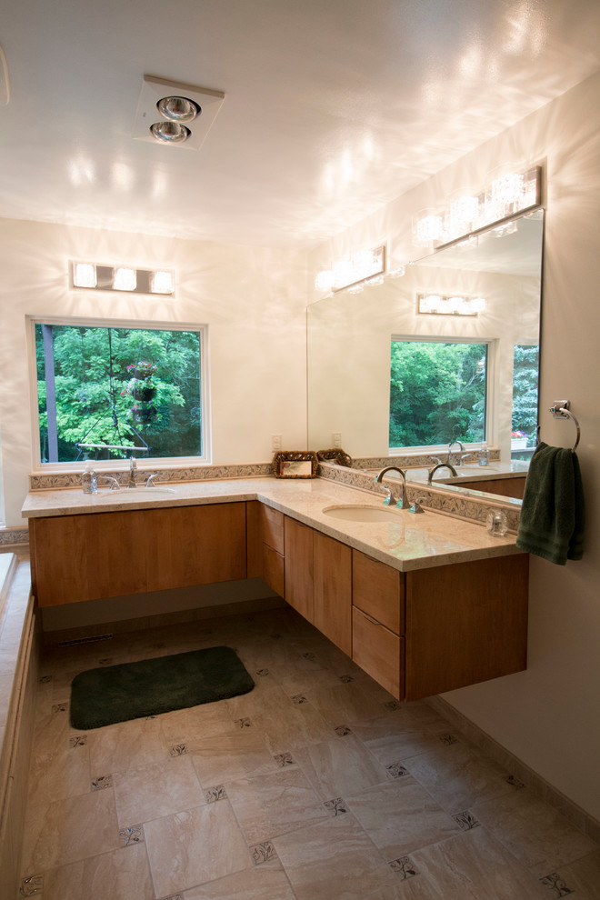 Mid-sized transitional master beige tile and ceramic tile ceramic tile drop-in bathtub photo with an undermount sink, flat-panel cabinets, light wood cabinets, solid surface countertops, a two-piece toilet and beige walls