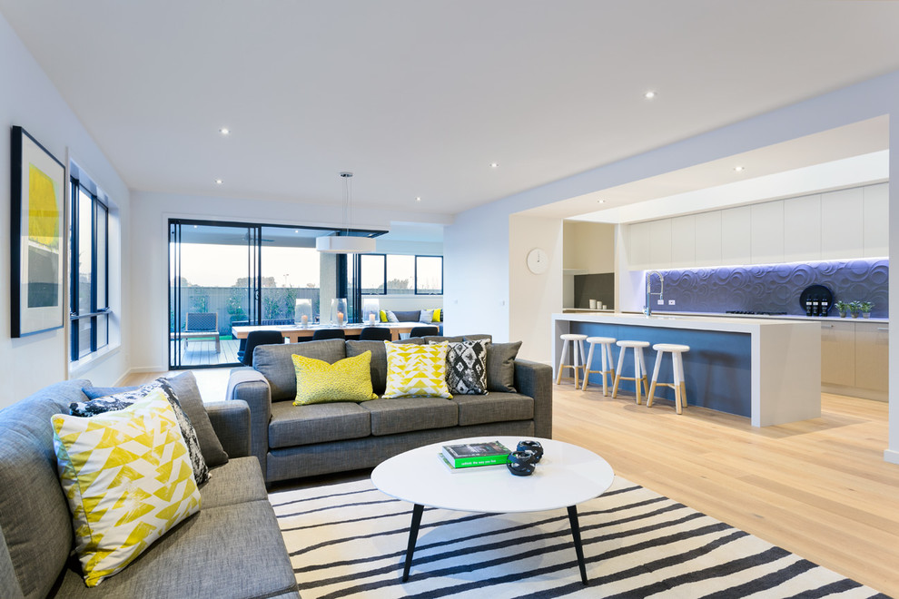 Photo of a large contemporary open concept living room in Melbourne with white walls, light hardwood floors and a wall-mounted tv.