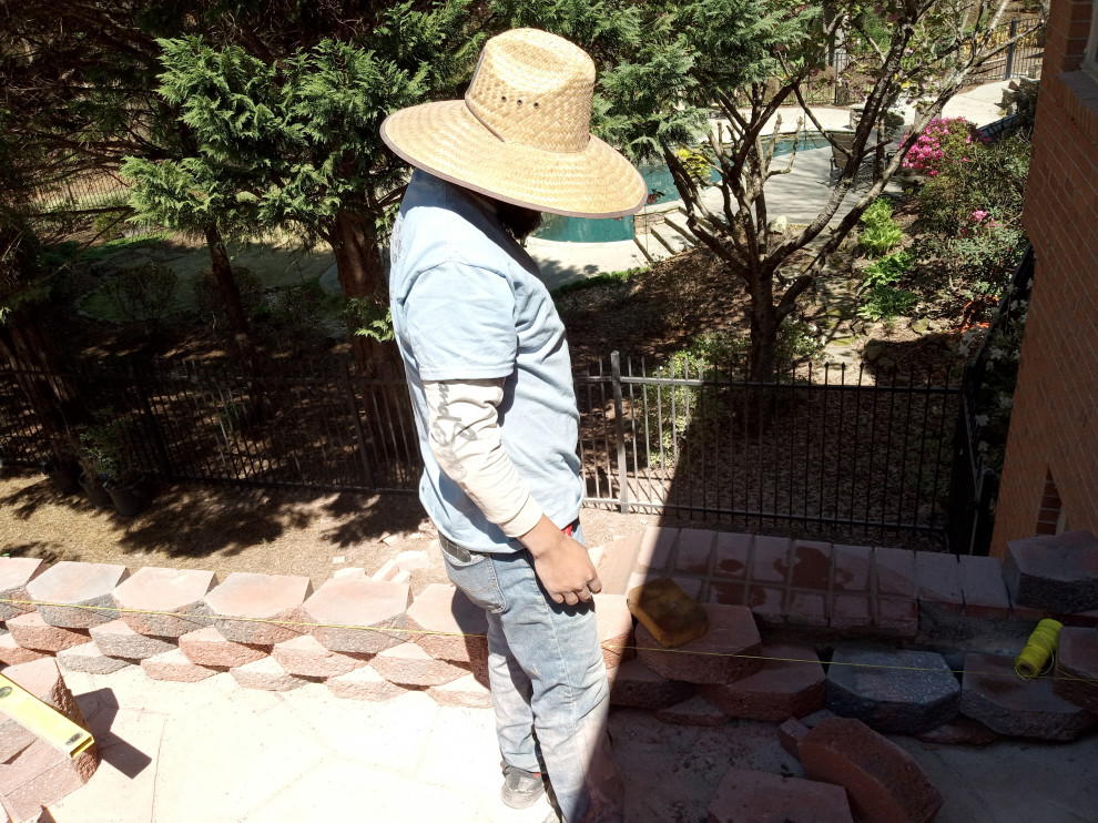 This is an example of a large craftsman privacy, rock and full sun backyard concrete paver retaining wall landscape for summer.