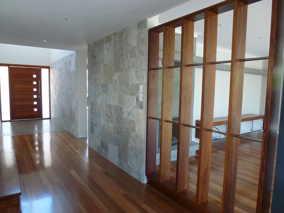 Large contemporary foyer in Brisbane with grey walls, medium hardwood floors, a pivot front door and a medium wood front door.