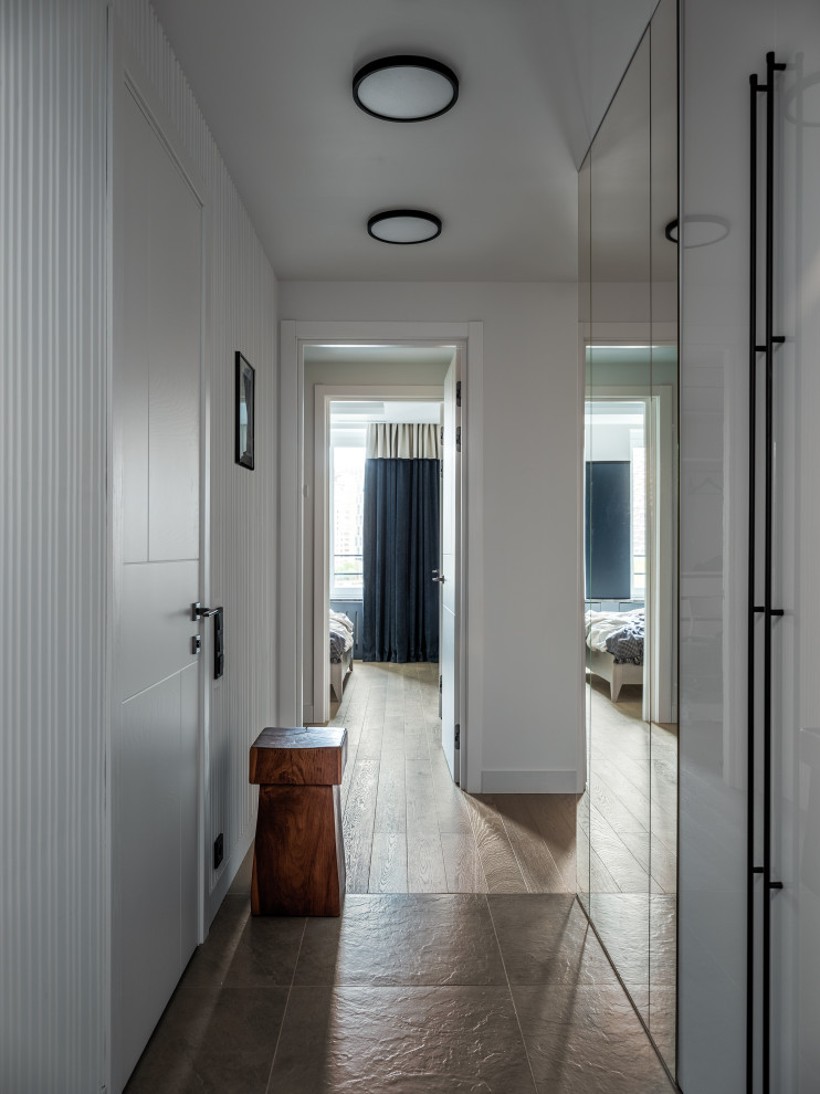 Diseño de hall contemporáneo pequeño con paredes blancas, suelo de baldosas de porcelana, puerta simple, puerta blanca, suelo gris, bandeja y panelado