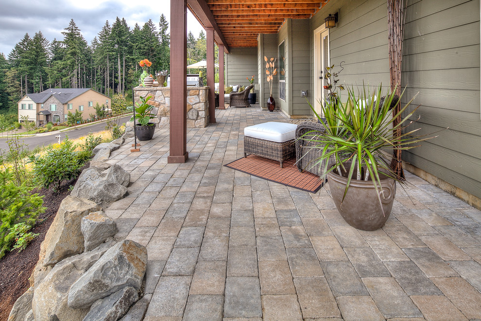 Large traditional backyard patio in Portland with a fire feature, concrete pavers and a roof extension.
