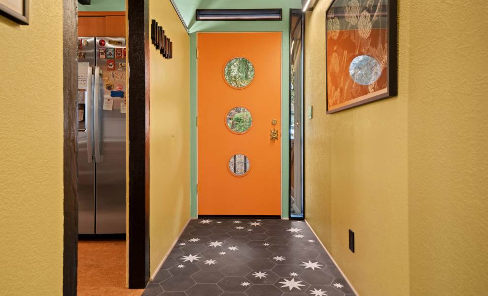 На фото: прихожая в стиле ретро с зелеными стенами, бетонным полом, одностворчатой входной дверью, оранжевой входной дверью, серым полом и деревянным потолком