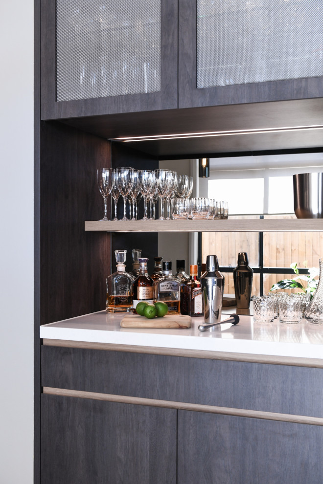 Photo of a small contemporary single-wall home bar in Sydney with no sink, dark wood cabinets, quartz benchtops, multi-coloured splashback, mirror splashback, ceramic floors and white benchtop.