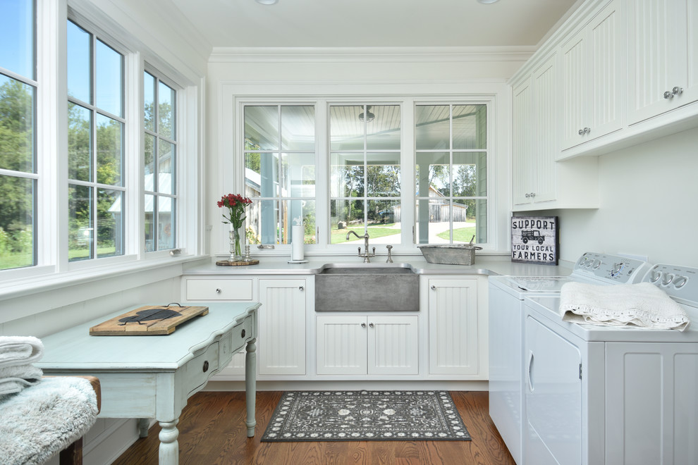 Design ideas for a country utility room in Other with a farmhouse sink, recessed-panel cabinets, white cabinets, white walls, dark hardwood floors, a side-by-side washer and dryer, brown floor, laminate benchtops and grey benchtop.