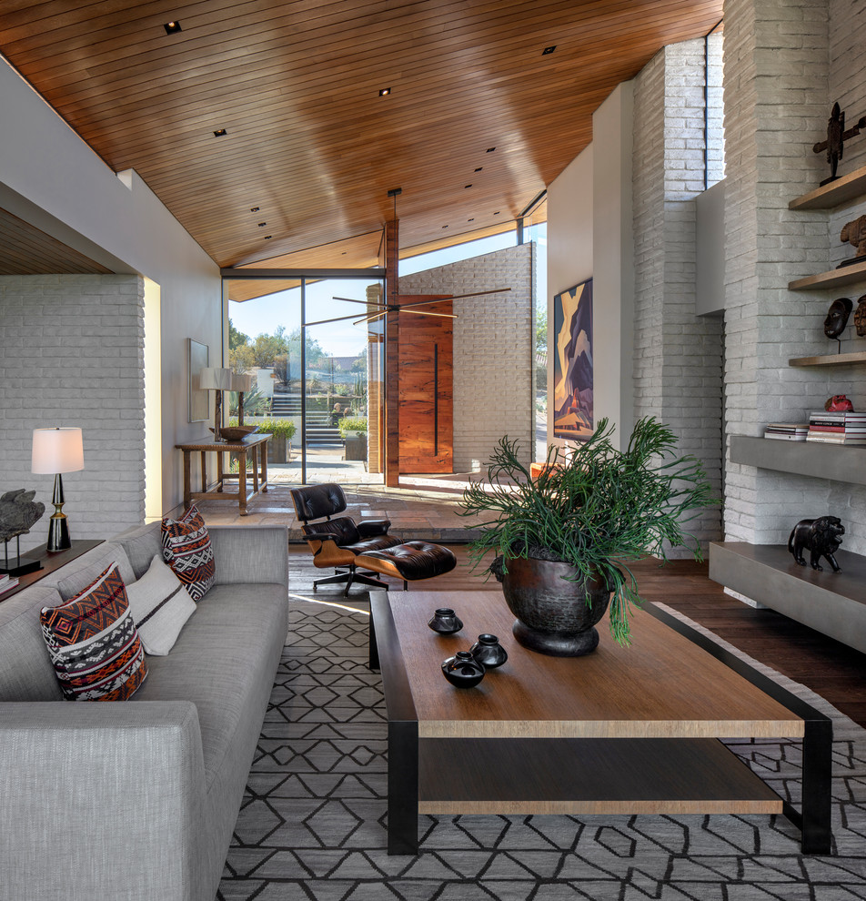 Contemporary living room in Phoenix with white walls, dark hardwood floors and brown floor.