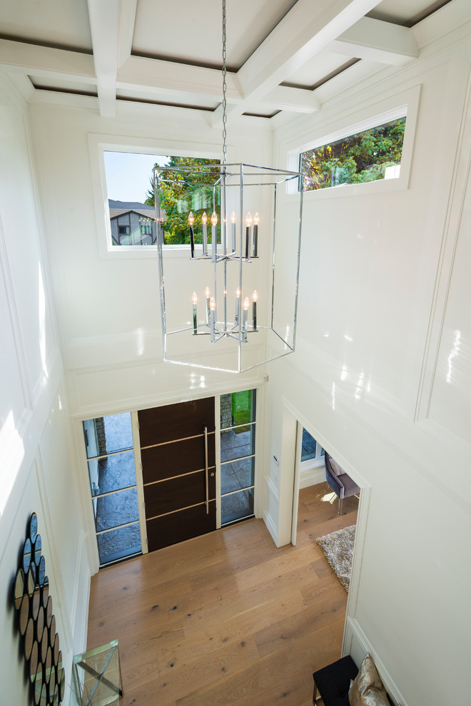 Example of a mid-sized transitional light wood floor and beige floor foyer design in Vancouver with white walls and a dark wood front door