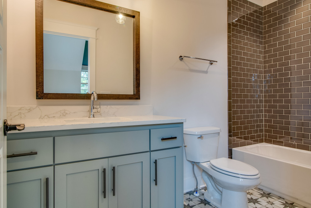 Photo of a mid-sized transitional kids bathroom in Nashville with shaker cabinets, white cabinets, an alcove tub, a corner shower, a two-piece toilet, white tile, porcelain tile, white walls, mosaic tile floors, an undermount sink, engineered quartz benchtops, blue floor and white benchtops.