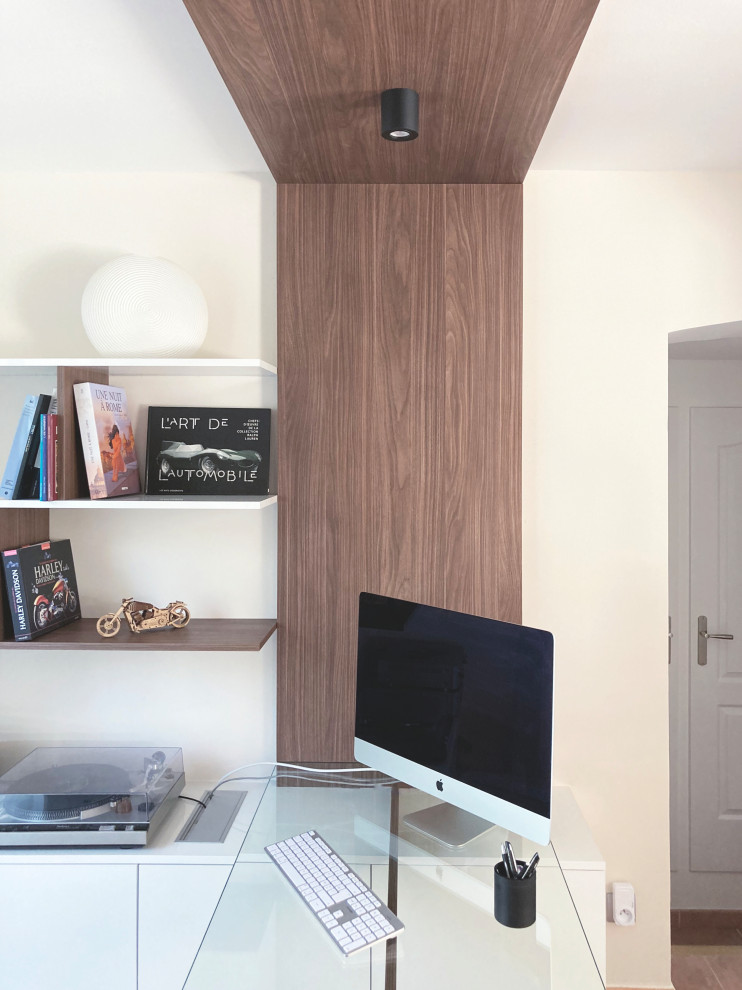 Imagen de despacho contemporáneo de tamaño medio sin chimenea con biblioteca, paredes beige, suelo de baldosas de cerámica, escritorio independiente y suelo rosa