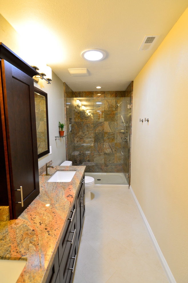 This is an example of a mid-sized contemporary master bathroom in Tampa with an undermount sink, furniture-like cabinets, dark wood cabinets, engineered quartz benchtops, a two-piece toilet, multi-coloured tile, stone tile, beige walls and porcelain floors.