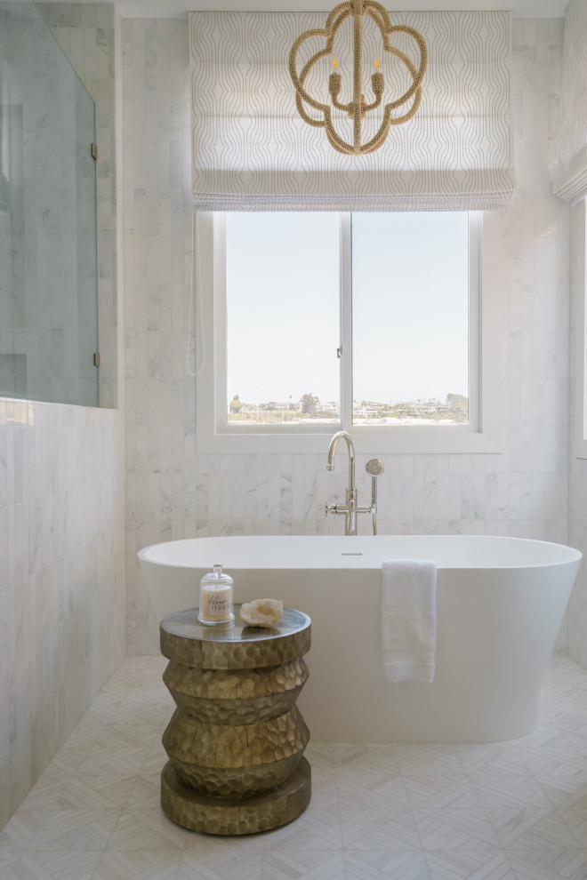This is an example of a large beach style master bathroom in Orange County with medium wood cabinets, a freestanding tub, an alcove shower, white tile, mirror tile, white walls, mosaic tile floors, quartzite benchtops, white floor, a hinged shower door, white benchtops, a double vanity, a built-in vanity and an undermount sink.