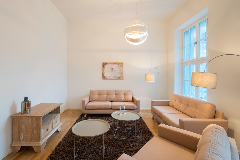 Wohnzimmer ohne Kamin With weißer Wandfarbe and braunem Holzboden in Leipzig