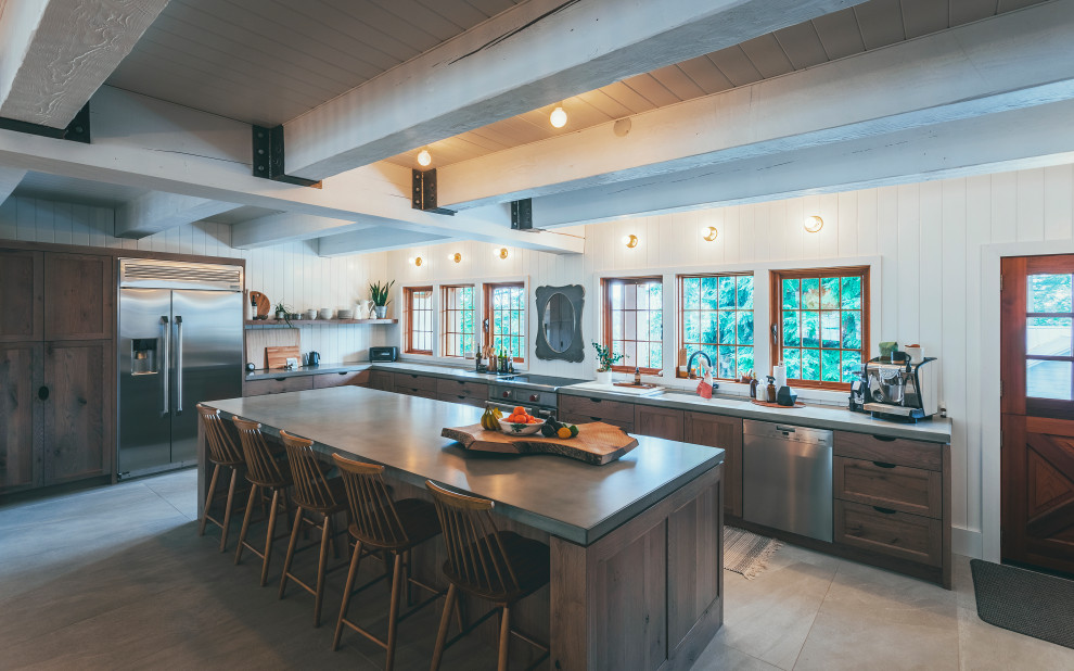 Inspiration for an expansive country l-shaped eat-in kitchen in Vancouver with an undermount sink, shaker cabinets, medium wood cabinets, concrete benchtops, white splashback, shiplap splashback, stainless steel appliances, porcelain floors, with island, beige floor, grey benchtop and timber.