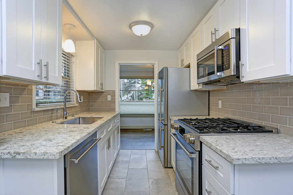 Inspiration for a transitional kitchen remodel with shaker cabinets, white cabinets, granite countertops, beige backsplash, cement tile backsplash, no island and multicolored countertops