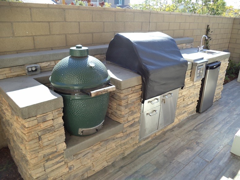 Photo of a contemporary backyard patio in Orange County with an outdoor kitchen and tile.