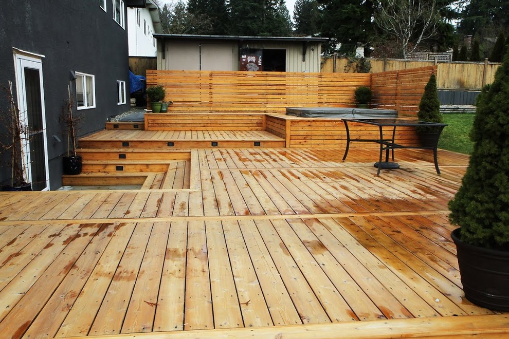 Large mountain style backyard water fountain deck photo in Vancouver with no cover