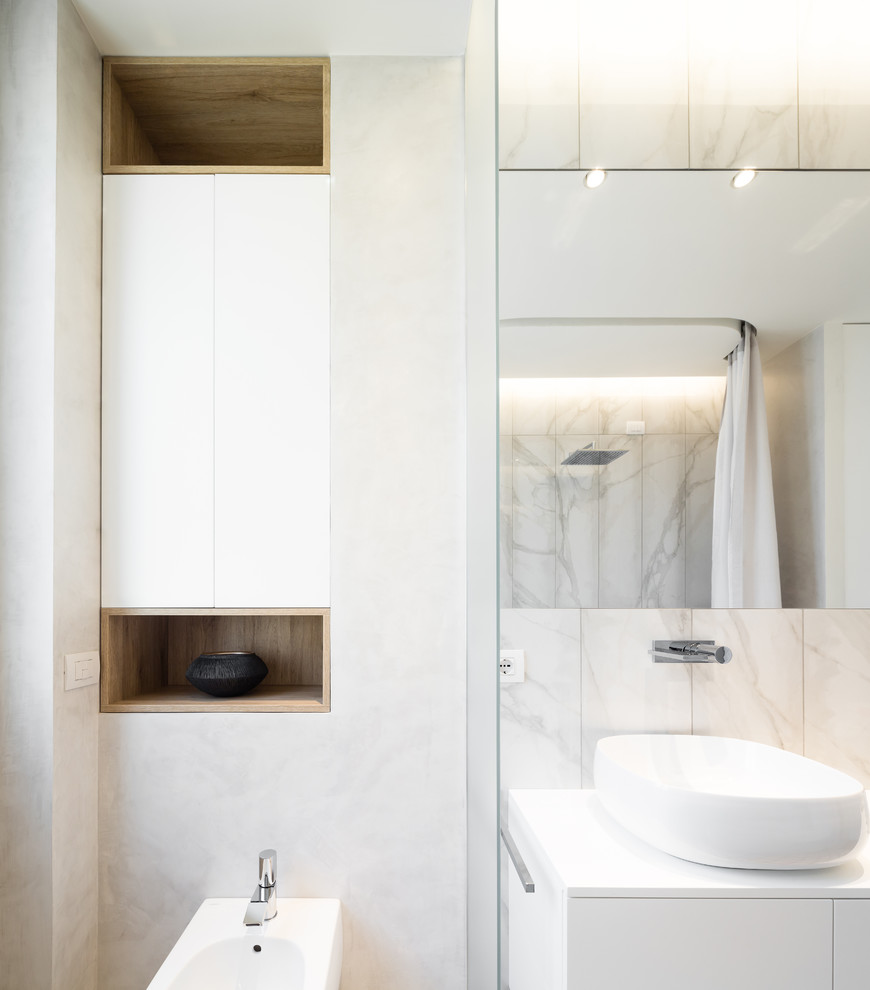 Inspiration for an expansive contemporary master bathroom in Milan with flat-panel cabinets, white cabinets, an alcove tub, an alcove shower, a two-piece toilet, white tile, marble, white walls, marble floors, a vessel sink, marble benchtops, white floor, a shower curtain and white benchtops.