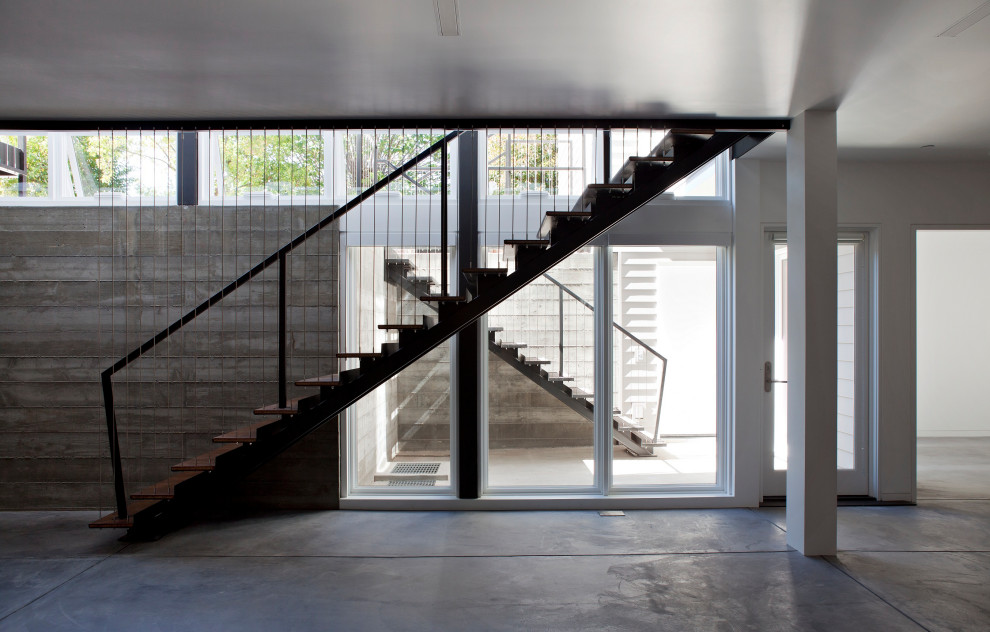 Ejemplo de escalera recta contemporánea con escalones de madera, contrahuellas de metal y barandilla de metal