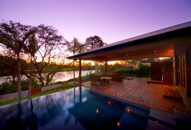 Design ideas for a mid-sized modern backyard deck in Sunshine Coast with a water feature and a roof extension.