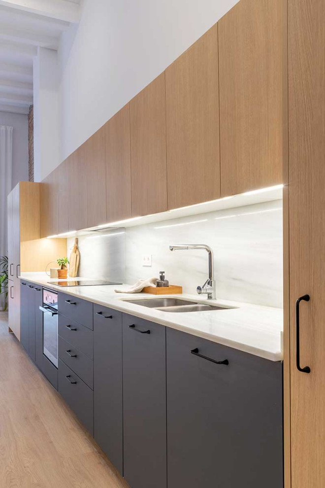 Photo of a modern kitchen in Barcelona with flat-panel cabinets.