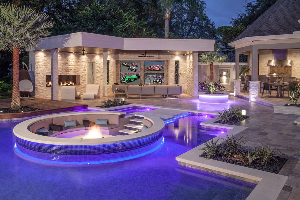 Design ideas for a large modern backyard custom-shaped pool in Tampa with natural stone pavers and a pool house.