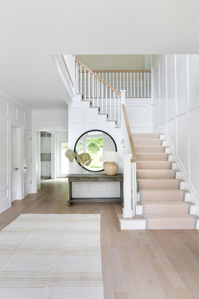 Design ideas for a large traditional foyer in New York with white walls, light hardwood floors, a single front door, a white front door and brown floor.
