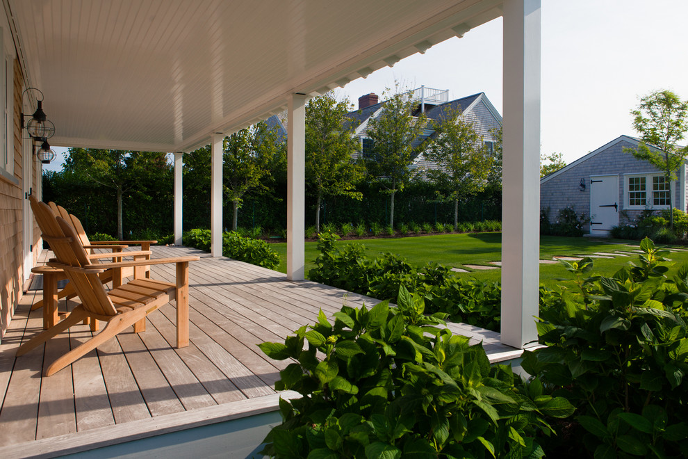 This is an example of a mid-sized beach style backyard verandah in Boston with a roof extension.