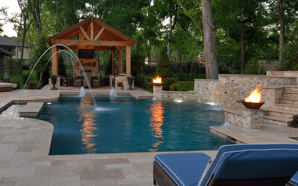 Photo of an expansive transitional backyard custom-shaped natural pool in Houston with natural stone pavers and a hot tub.