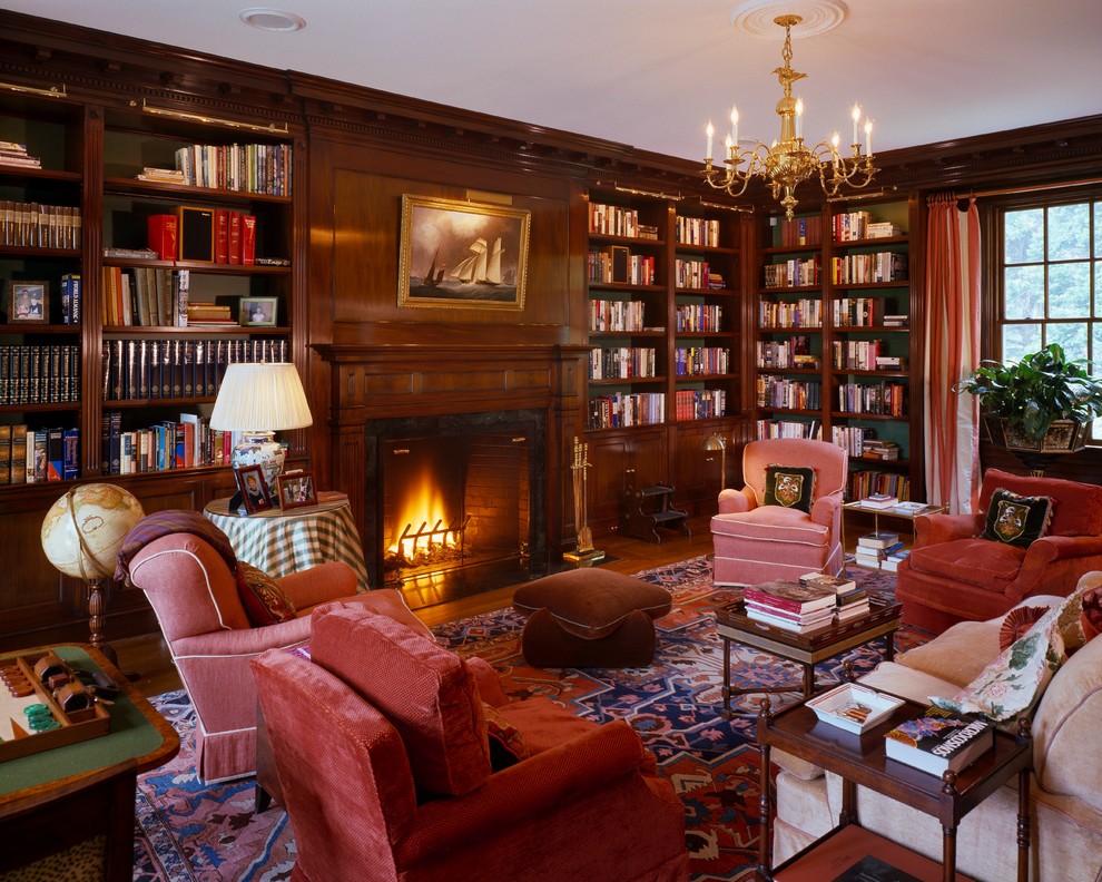 Inspiration for a large traditional enclosed living room in Boston with a library, medium hardwood floors, a standard fireplace, a stone fireplace surround, a built-in media wall, brown walls and brown floor.