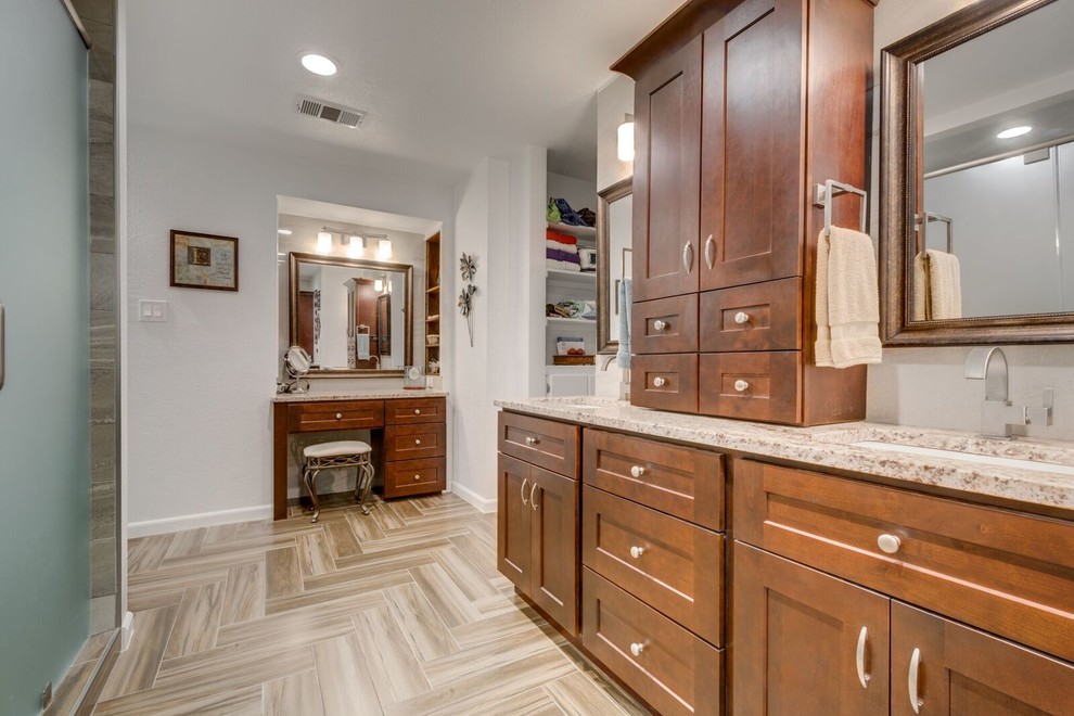 Inspiration for a large contemporary master bathroom in Dallas with raised-panel cabinets, medium wood cabinets, an alcove shower, beige tile, white walls, ceramic floors, a drop-in sink and granite benchtops.