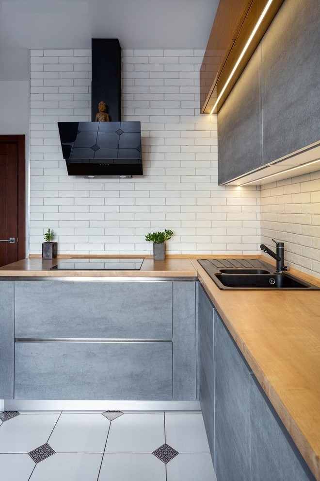 Design ideas for a small contemporary l-shaped separate kitchen in Moscow with laminate benchtops, white splashback, brick splashback, black appliances, ceramic floors and no island.