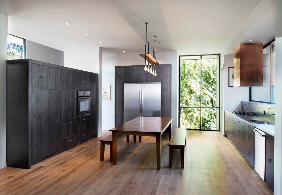 Inspiration for a contemporary u-shaped kitchen in Atlanta with flat-panel cabinets, dark wood cabinets, stainless steel appliances and with island.