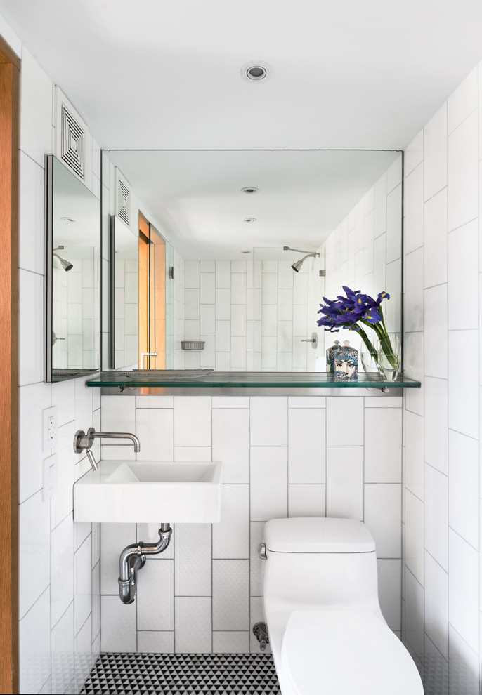 This is an example of a small contemporary 3/4 bathroom in New York with white tile, ceramic floors, a wall-mount sink and a one-piece toilet.