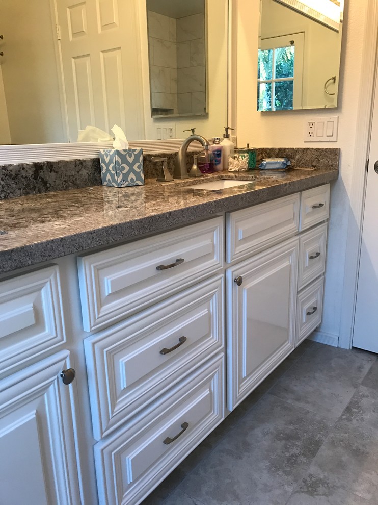 Photo of a small traditional 3/4 bathroom in Phoenix with louvered cabinets, white cabinets, an open shower, a two-piece toilet, gray tile, porcelain tile, white walls, pebble tile floors, an undermount sink and granite benchtops.