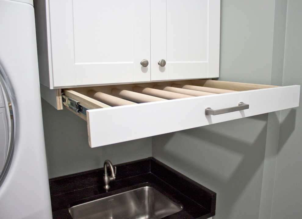 Example of a mid-sized transitional ceramic tile and gray floor home design design with an undermount sink, shaker cabinets, white cabinets, granite countertops, gray walls and a stacked washer/dryer