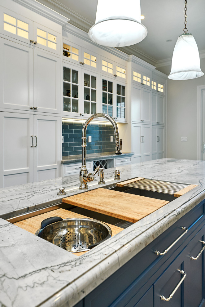 Idéer för ett stort klassiskt blå kök, med en trippel diskho, luckor med profilerade fronter, vita skåp, bänkskiva i kvartsit, blått stänkskydd, stänkskydd i keramik, integrerade vitvaror, klinkergolv i porslin, en köksö och grått golv