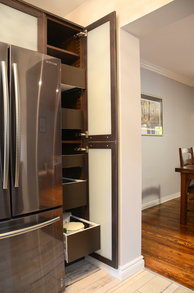 Inspiration for a mid-sized transitional galley porcelain tile kitchen remodel in Ottawa with an undermount sink, glass-front cabinets, brown cabinets, quartz countertops, brown backsplash, glass sheet backsplash and stainless steel appliances