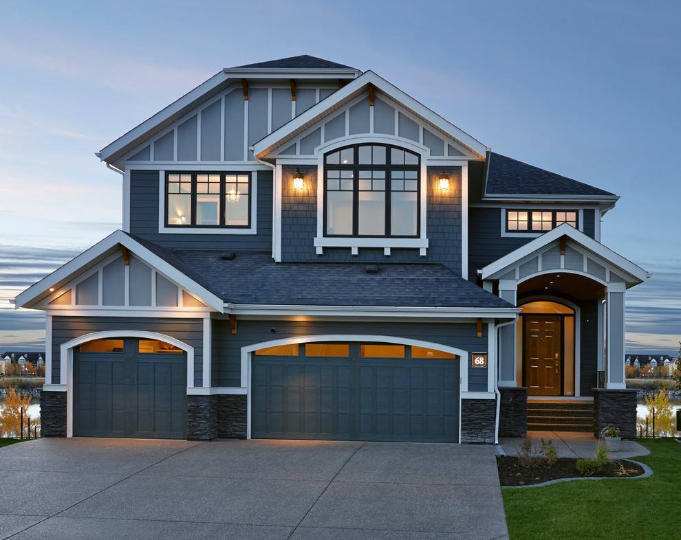 This is an example of a transitional two-storey blue exterior in Calgary with mixed siding.