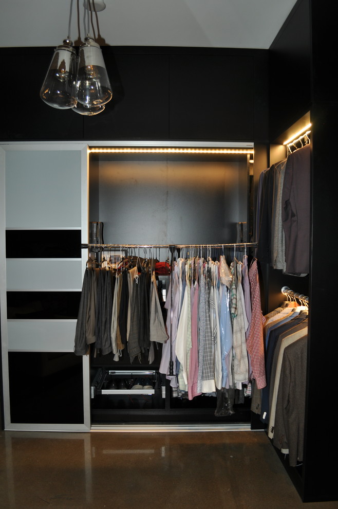 Inspiration for a small modern men's dressing room in Toronto with flat-panel cabinets, black cabinets, concrete floors and grey floor.