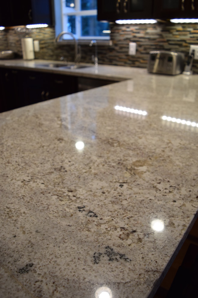 Inspiration for a mid-sized rustic u-shaped eat-in kitchen remodel with an undermount sink, recessed-panel cabinets, dark wood cabinets, granite countertops, multicolored backsplash and a peninsula